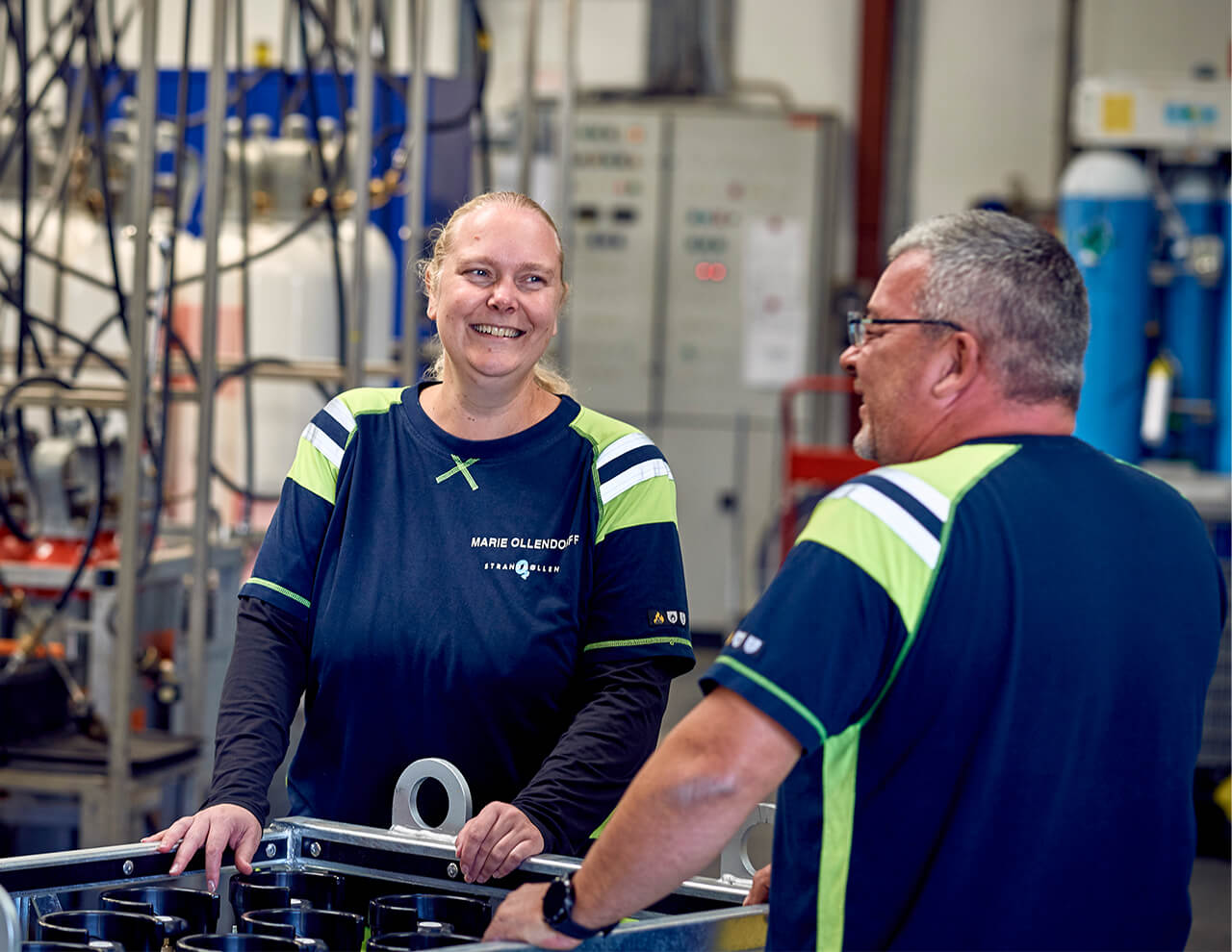 Glad medarbejder på Strandmøllen snakker sammen på fabrik. Arbejde i gas industri. 
